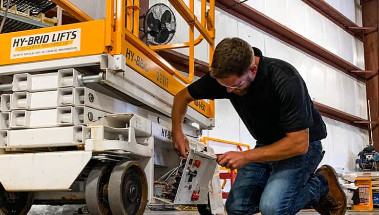 Service technician working on scissor lift